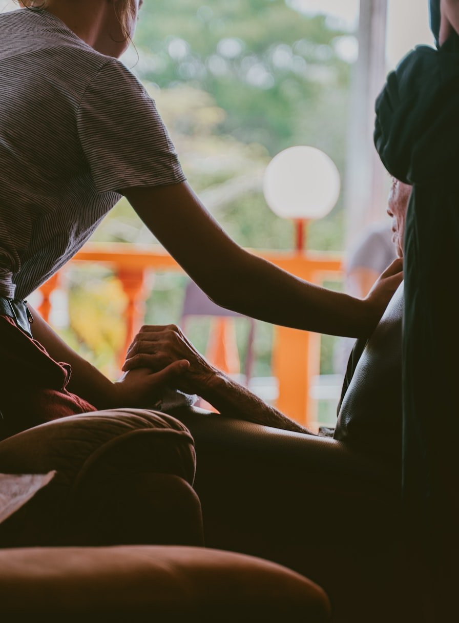 Cuidadora segurando as mãos de um idoso